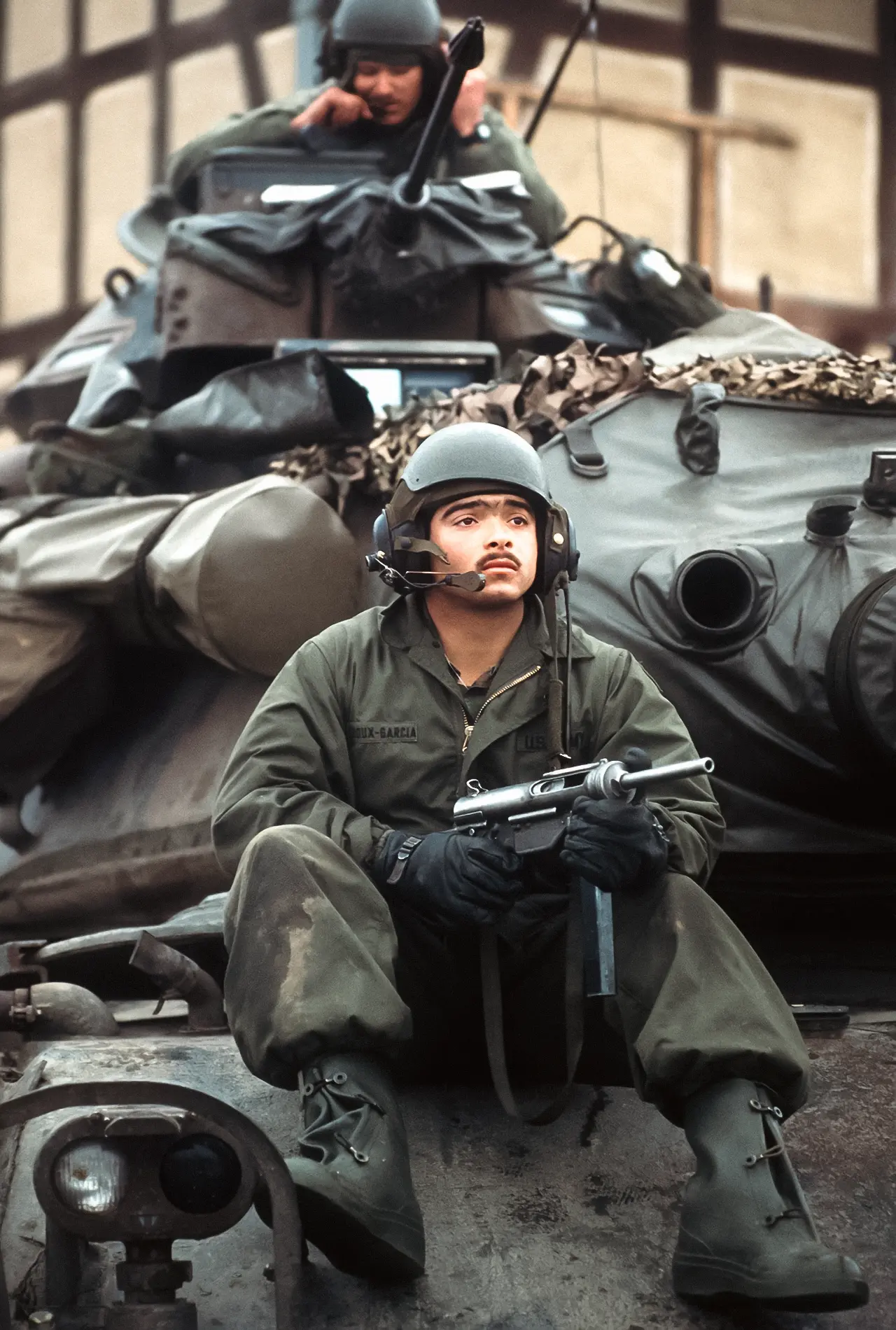 A US Army tanker holds his M3 Grease Gun atop an M60A3 MBT during Exercise Reforger, 1985